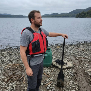 Chaleco salvavidas Dukha rojo puesto en la orilla de un lago