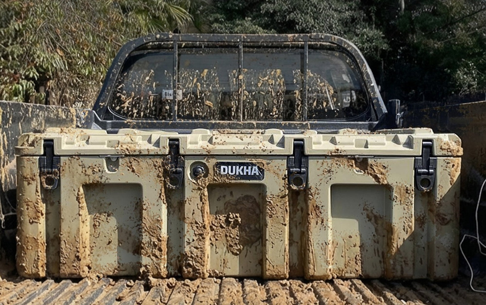 Hard case DUKHA cubierto de barro en la pick-up, después de un día de terreno