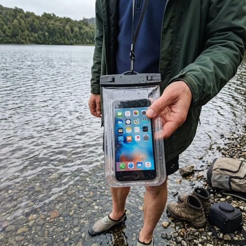 Funda impermeable IPX8 para celular colgada al cuello en la orilla de un lago