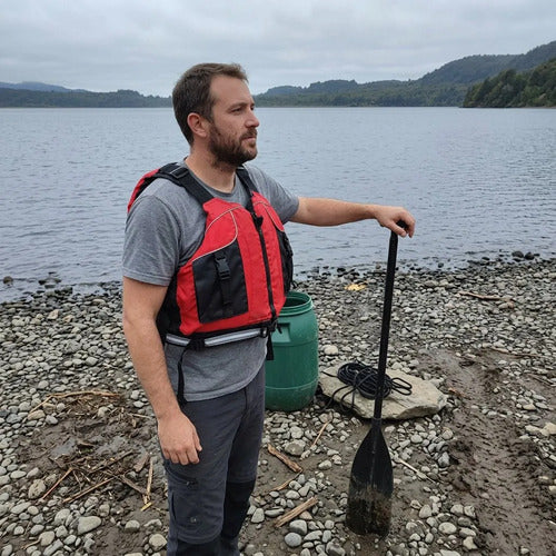 Chaleco salvavidas Dukha rojo puesto en la orilla de un lago